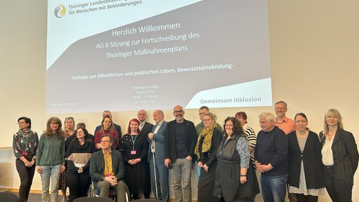Gruppenfoto der Mitglieder der AG 8 vor Präsentationsleinwand
